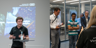 Das Bild stellt zwei Apsekte dar: Linker Teil: Nils Killich hält einen Vortrag. Rechte Seite: Mehrere Personen höhren einem Vortrag in einer Produktionshalle zu