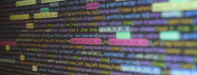Nahaufnahme eines Computerbildschirms mit farbig hervorgehobenem Code. Verschiedene Codezeilen in bunten Markierungen.