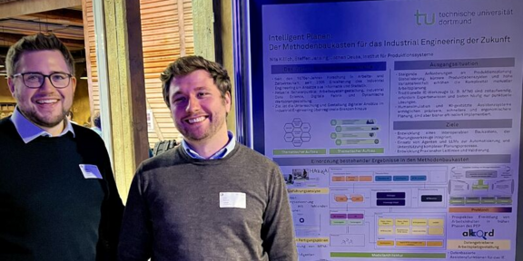 Zwei Personen vor Poster zur intelligenten Produktionsplanung.