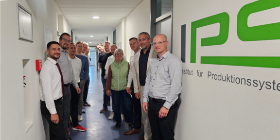 Gruppenbild mit den Teilnehmenden der ersten Sitzung des Projektbegleitenden Ausschusses neben dem IPS-Logo