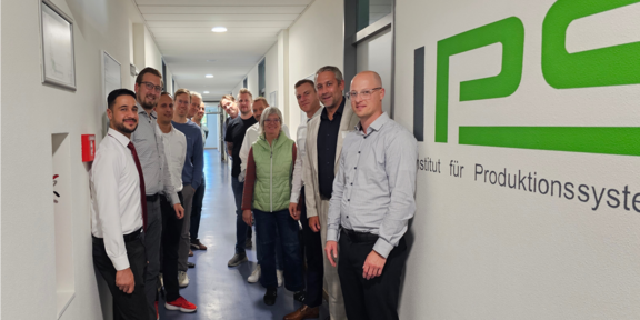 Gruppenbild mit den Teilnehmenden der ersten Sitzung des Projektbegleitenden Ausschusses neben dem IPS-Logo
