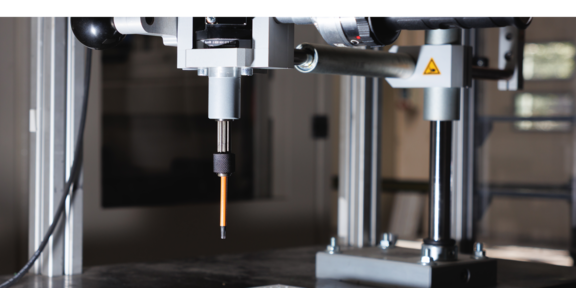 Ein handgeführtes Schraubsystem mit Schraubwerkzeug über einer Lochplatte in einer Laborumgebung.