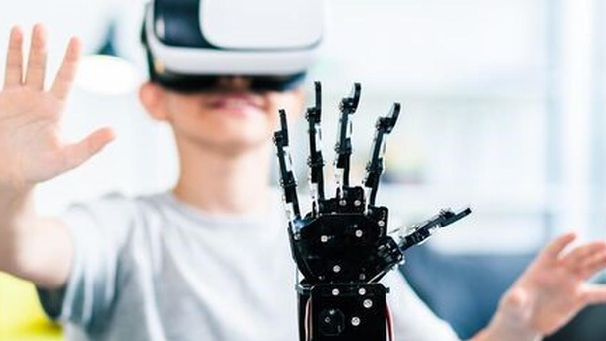 Kind mit VR-Brille und selbst gesteuertem Roboter