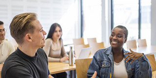 Studierende unterhalten sich im Seminarraum